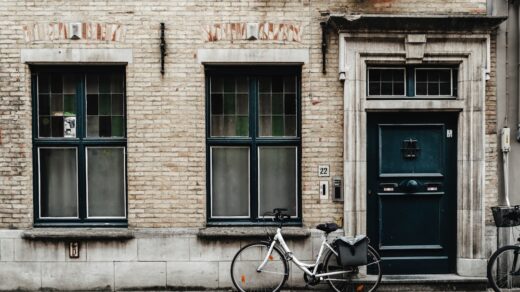 black bicycle parked beside brown brick building