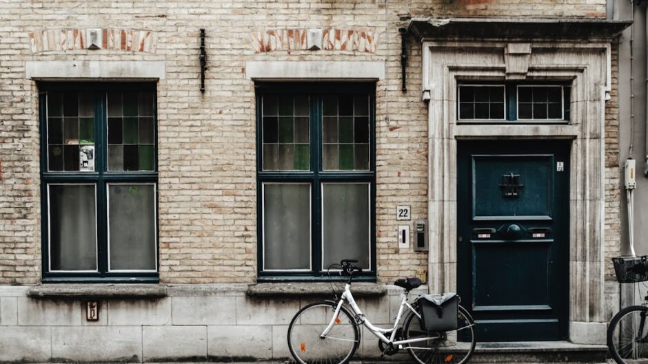 black bicycle parked beside brown brick building